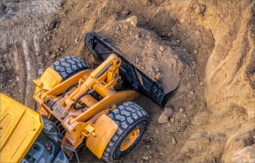 Construction equipment moving dirt in hole