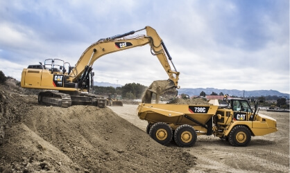 Cat equipment dumping dirt into CAT truck