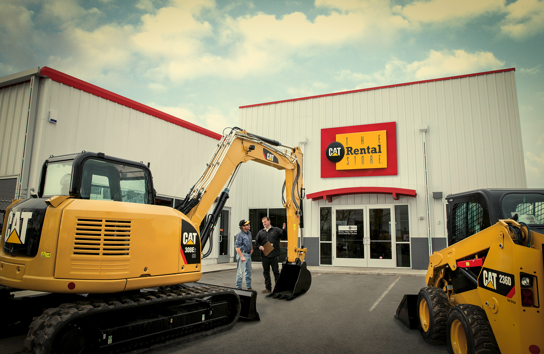 The CAT Rental Store with two men looking at CAT equipment