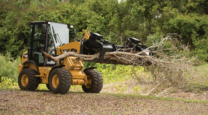 CAT compact equipment moving tree limbs