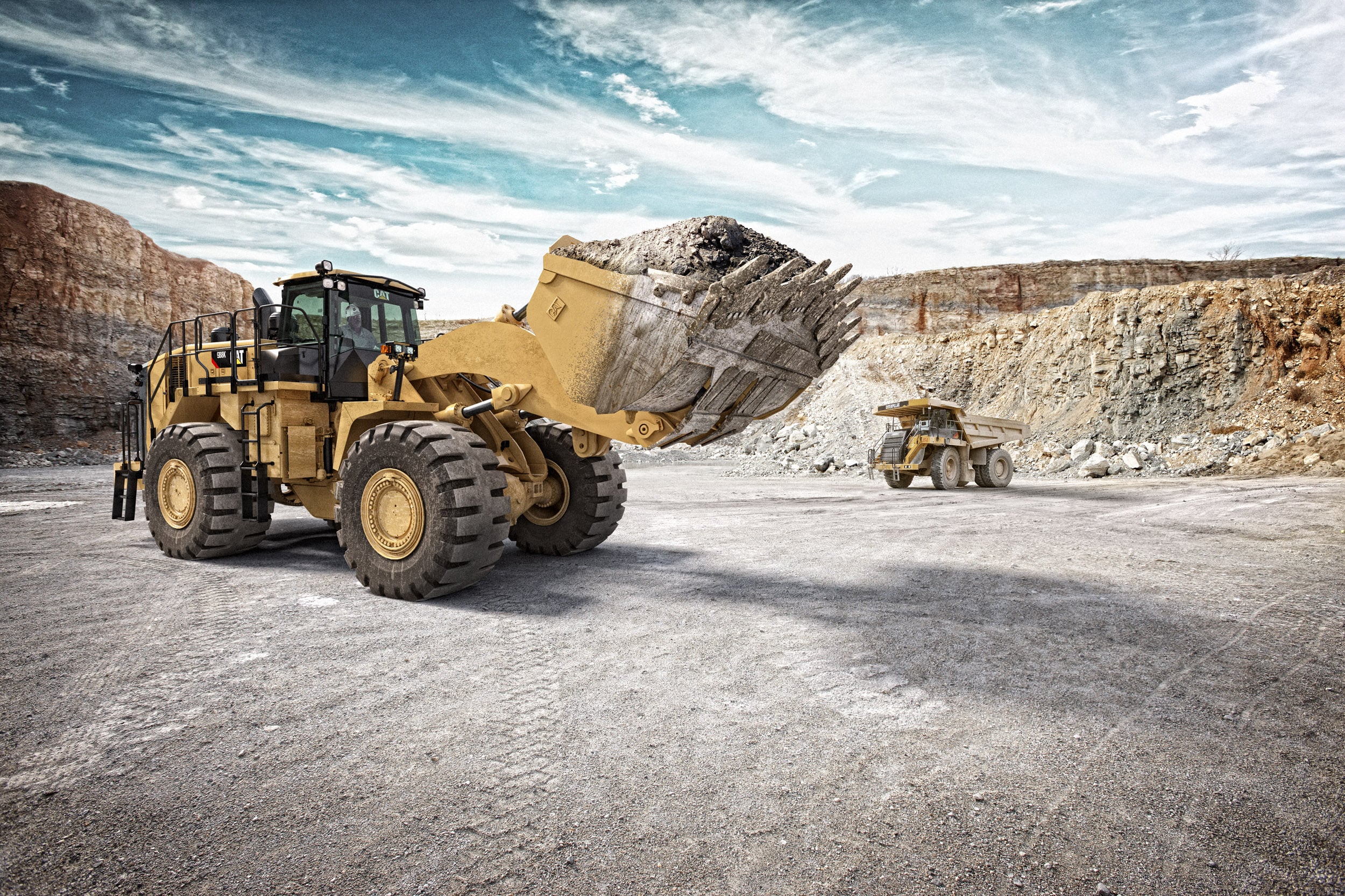 CAT construction equipment moving rocks at construction site